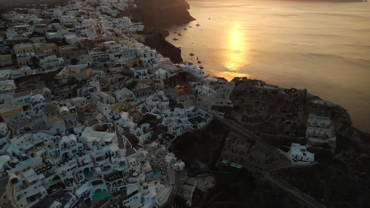 vista aérea de la puesta de sol sobre el pueblo de oia, la isla de santorini y el mar egeo, grecia