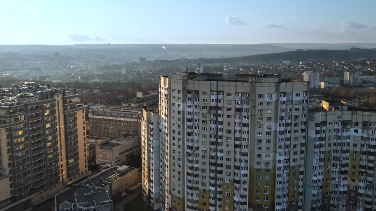 Aerial drone view of Chisinau, Moldova at sunset. Residential soviet building, cityscape on the background. Bare trees, winter