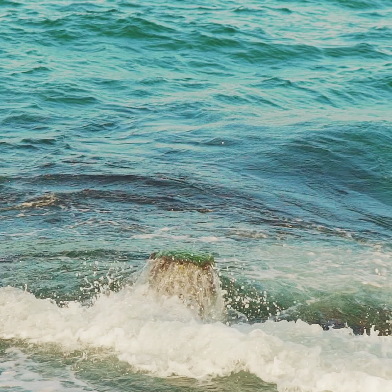 Breakwater and splashes of wave in sea shore. Slow motion
