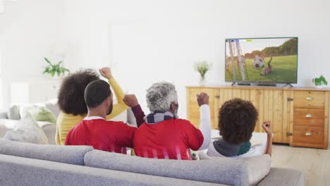 video of african american family sitting on the couch and watching football match