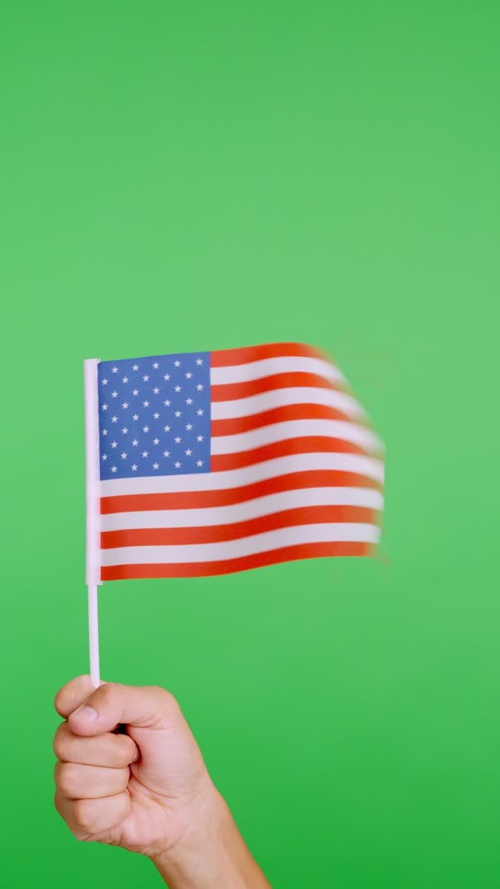 Hand lifting a USA pennant while waving by the wind