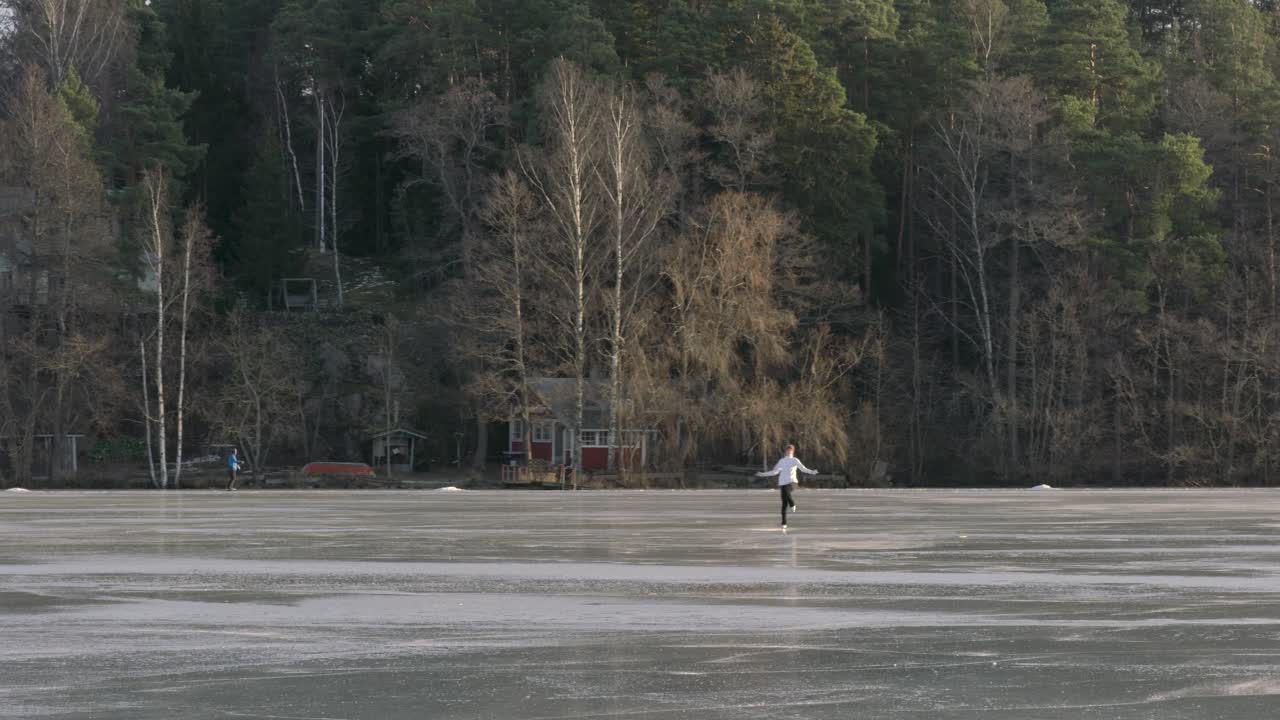 Ice skating girl doing a pirouette on a frozen lake. Figure skating