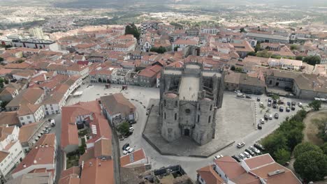 a huge gothic cathedral rises above the roofs of regular homes in guarda, portugal