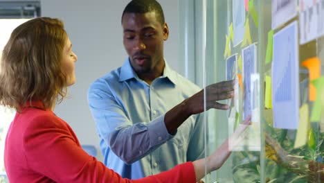 Mixed-race-business-colleagues-discussing-over-graph-in-modern-office-4k