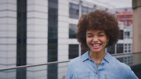 Portrait-Of-Smiling-Young-Businesswoman-Standing-Outside-Modern-Office