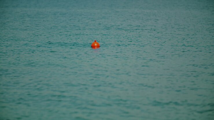 Orange Buoy Floating Calmly on Turquoise Ocean Water