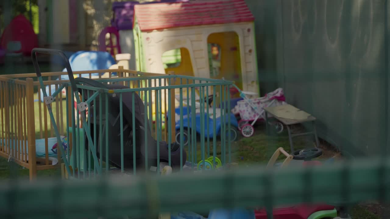 Kindergarten or playground with toys and cribs, focus to the foreground wire fence. school safety, restricted access, supervision standards, closures, investigations. lonely, sad, harassment, abuse
