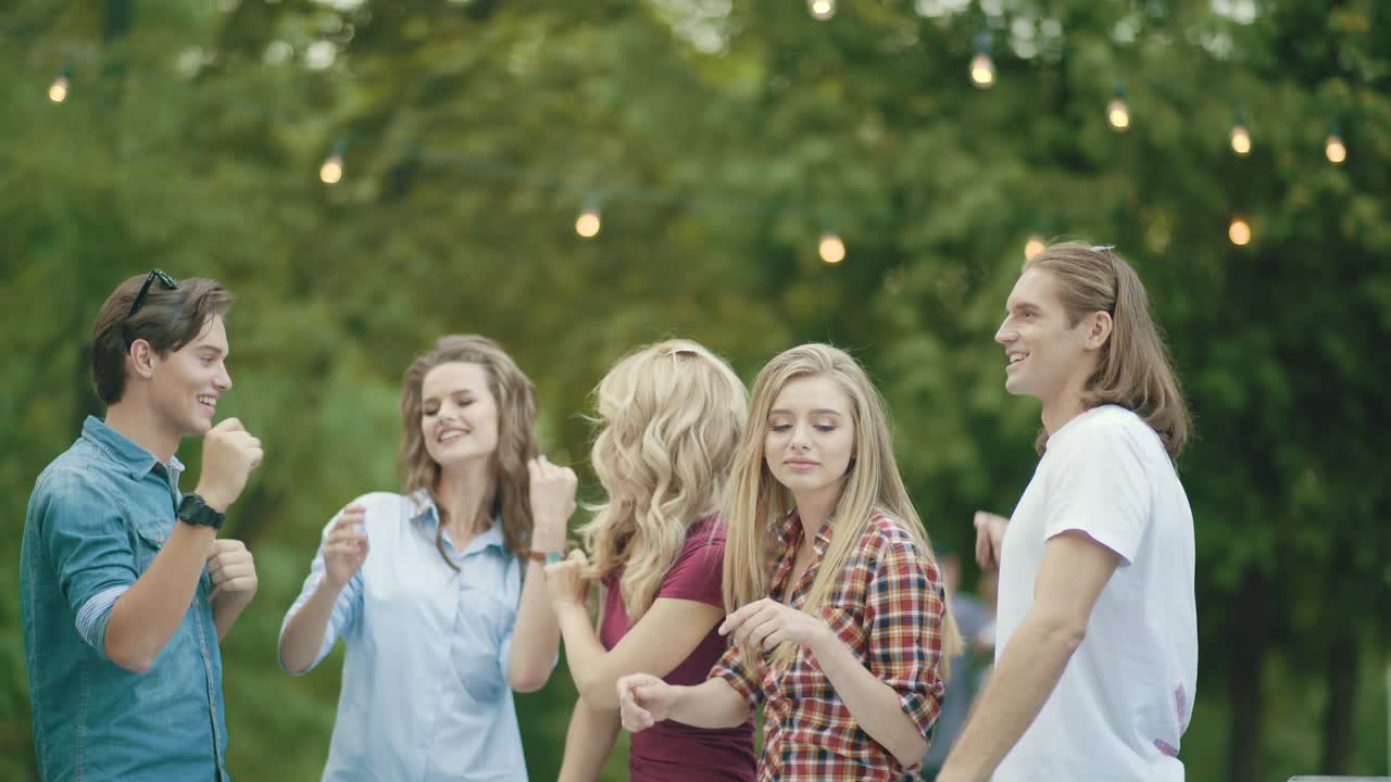 행복한 친구들이 춤을 추고, 재미를 느끼고, 야외 파티를 즐기고 있습니다.