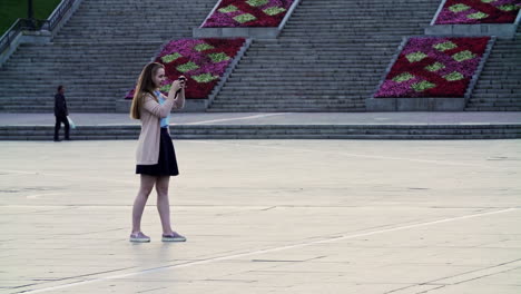 woman taking picture in a city square