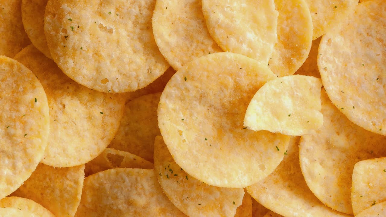 Background and texture of a heap of rotating potato chips.