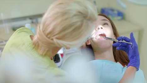 dentist using mouth mirror and medicine syringe in work. anesthetic injection