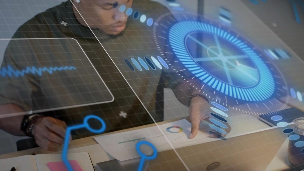 Male designer writing sticky notes and tapping touchpad with blue HUD sweeping design workflow