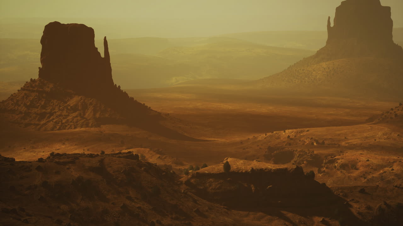 Expansive desert landscape showcasing massive rock formations at sunset