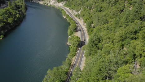 aerial in plumas national forest flying over highway 70 with beautiful calm lake