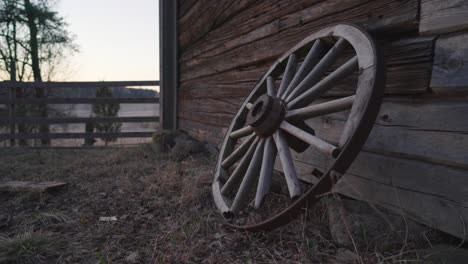 Old-broken-cart-wheel-leaning-against-a-barn