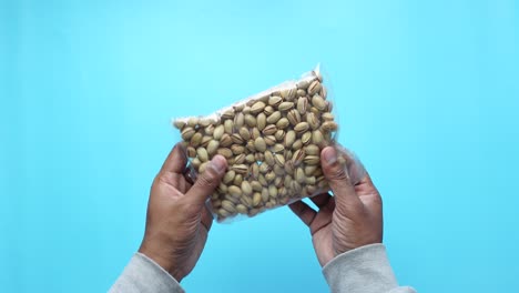 hands holding a bag of pistachios