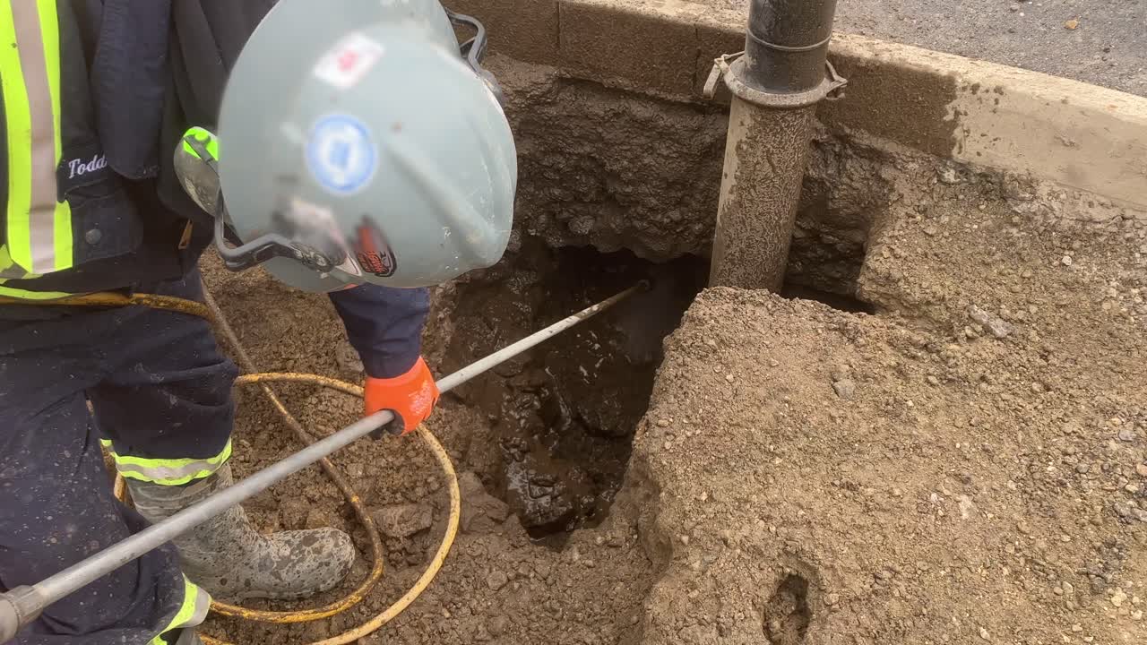 trabajador de la construcción ayuda en la excavación eficiente y segura de líneas de servicios públicos con camión hidrovac