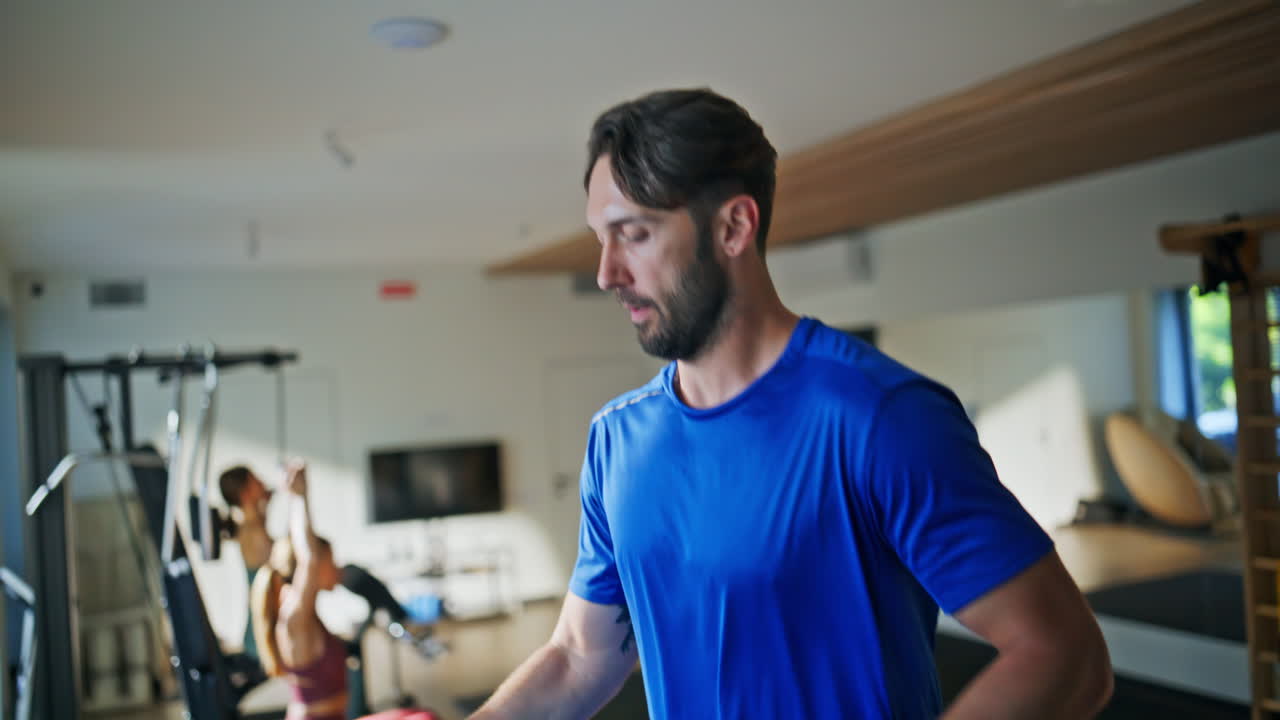 Primo piano di un runner energico che si allena sul tapis roulant in palestra. Sportivo attivo che corre