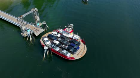 Aerial-view-of-a-small-ferry-filled-with-cars-departing-from-Herron-Island-in-Washington-State