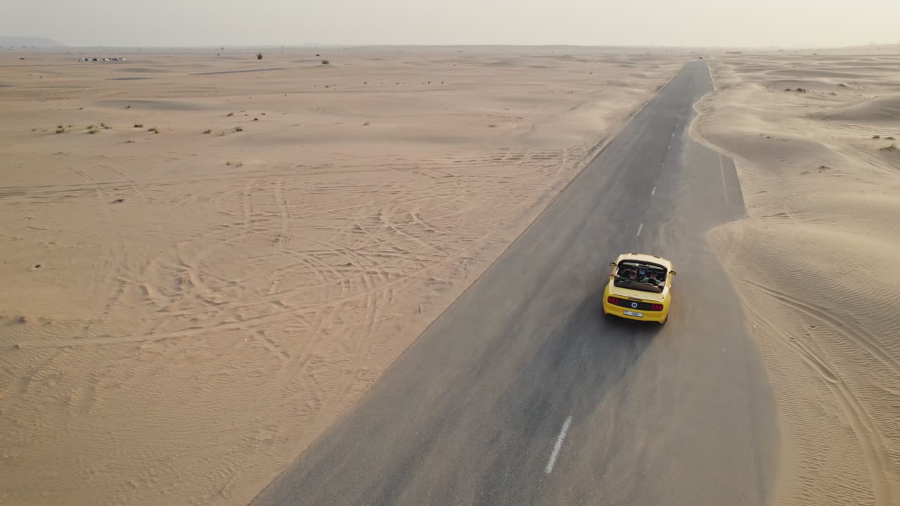 mustang descapotable amarillo conduciendo a través del desierto