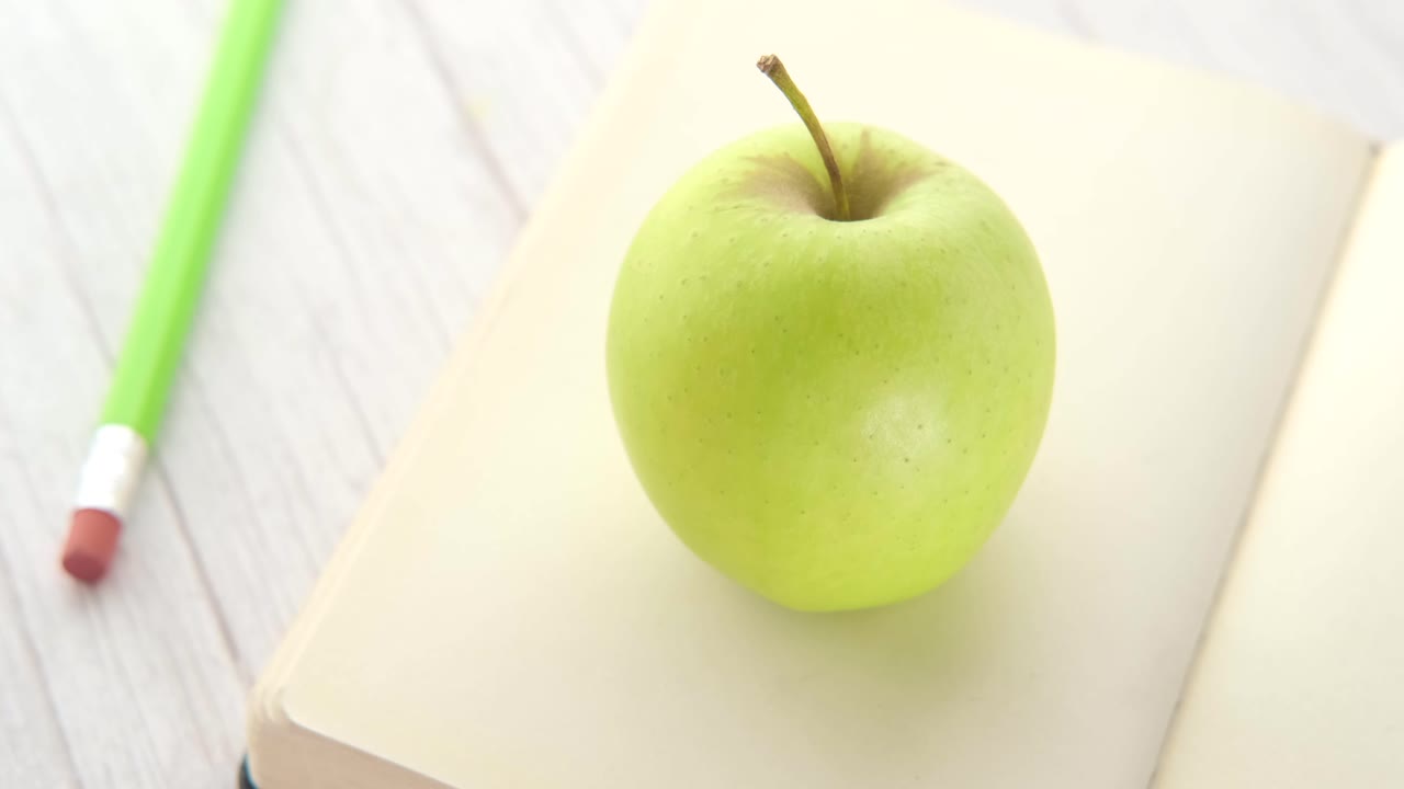 manzana verde en un libro abierto