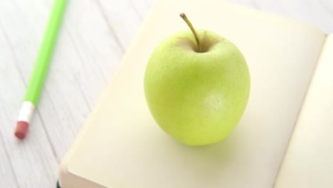 manzana verde en un libro abierto