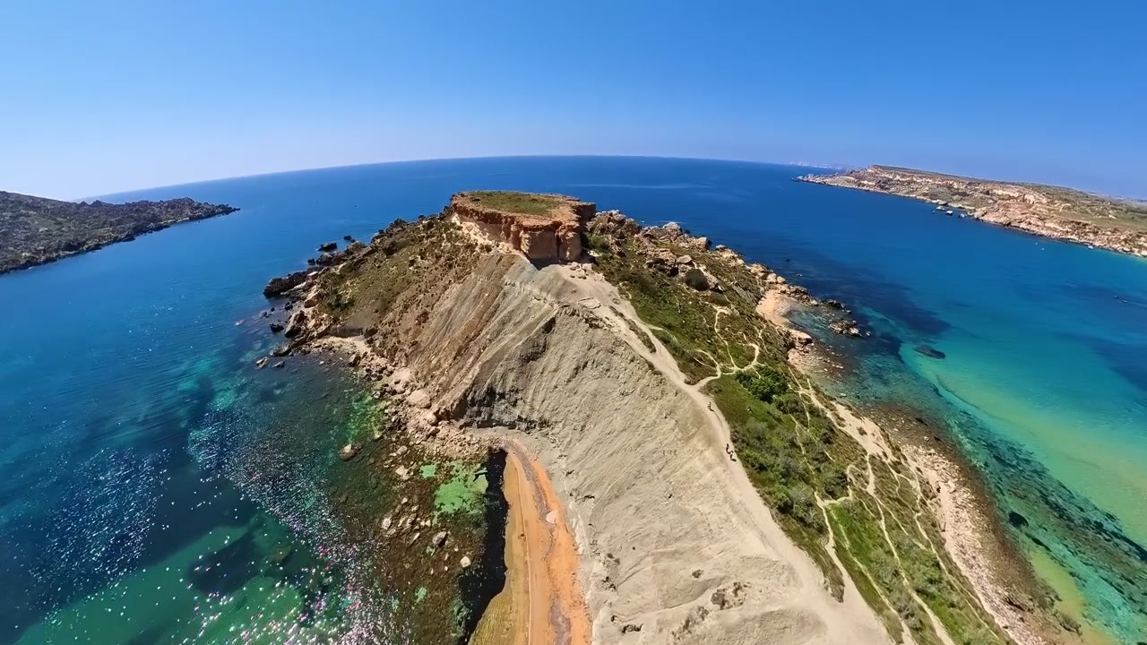 Panoramatické, letecké video Hliněných útesů mezi zálivem Qarraba a Ghajn Tuffieha na Maltě, oblíbené turistické místo na ostrově