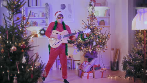 young man playing guitar in decorated home during christmas