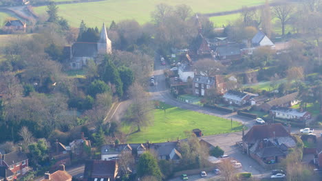 wide aerial view of high halden village, located in kent uk, with a pan up reveal of winters sun haze over the landscape