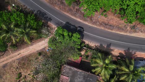 Toma-Aérea-De-Auto-rickshaw-En-La-Carretera-Rodeada-De-árboles