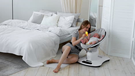 in the white bedroom engaged in online shopping while on maternity leave, sleeping next to the baby