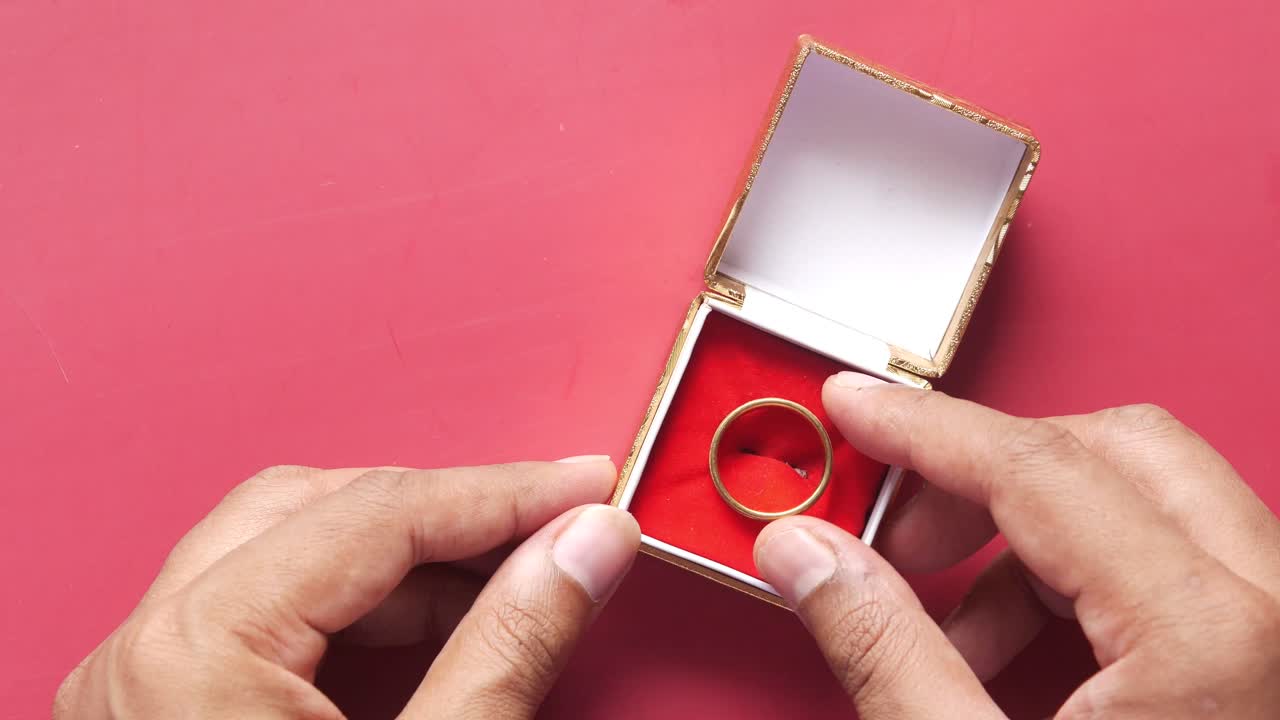 빨간 상자 에 금 반지 를 들고 있는 손 들