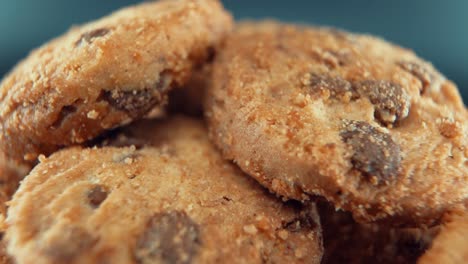 a macro close up cinematic shot of a plate full of crispy chocolate chip cookies, on a rotating stand, studio lighting, super slow motion, 120 fps, full hd