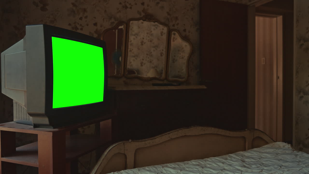 Old CRT Television with Green Screen in Abandoned Dusty Bedroom