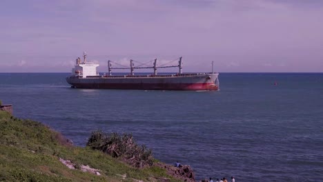 cargo ship sailing by the coast