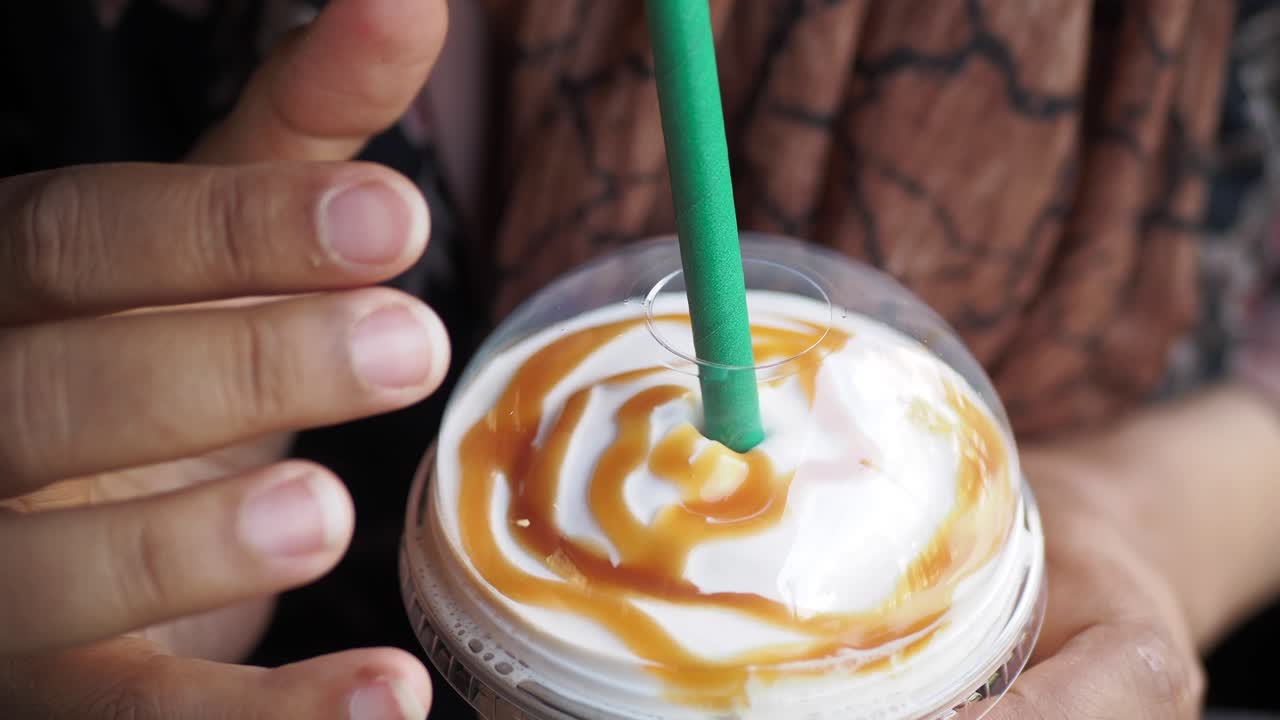 mujer sosteniendo una bebida de caramelo