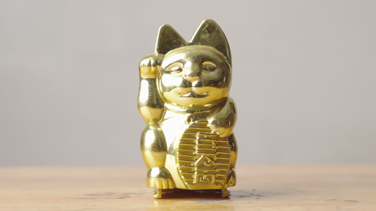 de la sombra a la luz, maneki-neko, una estatuilla japonesa de plástico común