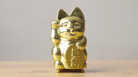 From-shadow-into-light,-Maneki-neko,-common-plastic-Japanese-Figurine