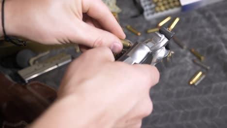 60p-slomotion: top down of looking down an empty revolver cylinder, checking it is clear