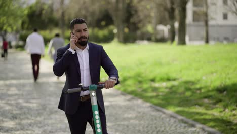 Businessman-on-scooter-answering-phone-call-outdoor