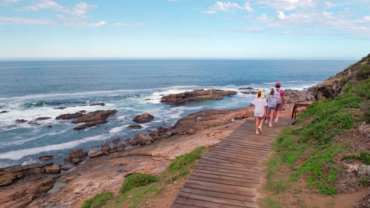 Família faz trilha em passarela de madeira na Área Marinha Protegida de Robberg na Rota Jardim.