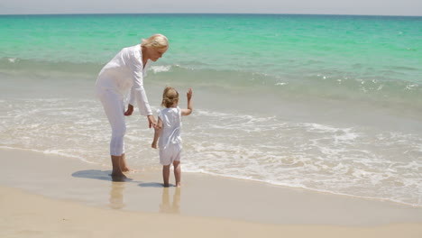 Großmutter-Und-Kleines-Mädchen-Genießen-Am-Strand