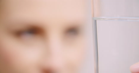 극단적인 물 유리를 보고 여자의 클로즈업