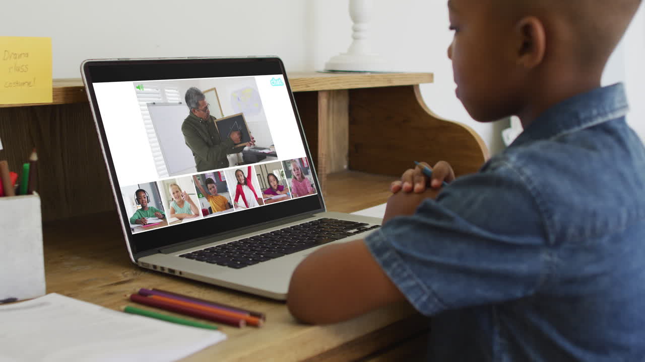 escolar que usa una computadora portátil para una lección en línea en casa, con un maestro y una clase diversos en la pantalla