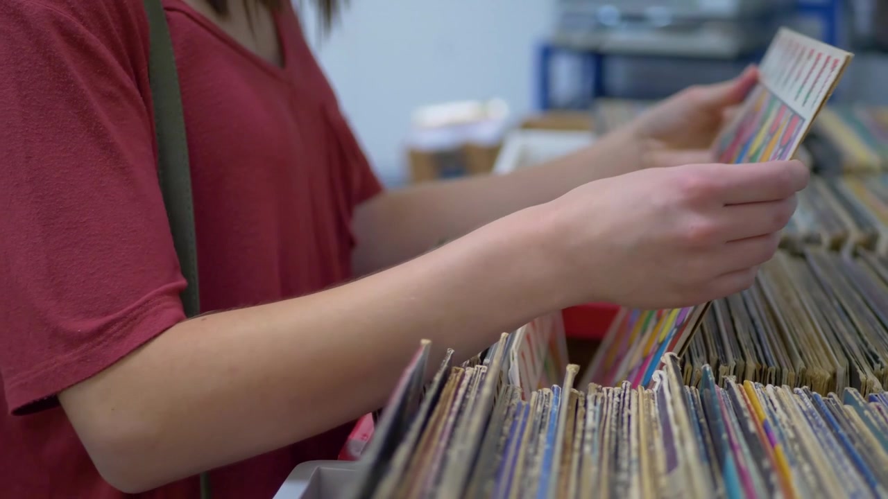 Close up of girl looking through vinyl records at music store