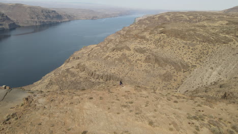 drone-footage-capturing-two-people-on-a-desert-cliff