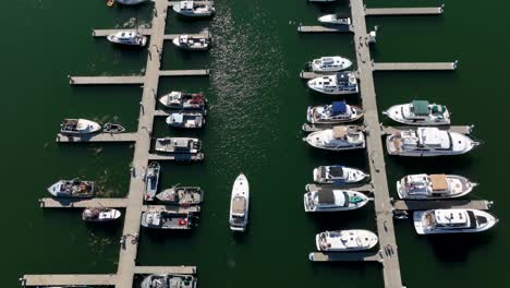 top down aerial shot of a boat slowing traveling to their assigned dock spot in a marina