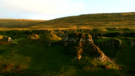 aerial view of couple visiting the green hills of fairy glen in scottish highlands