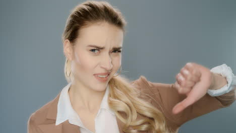 mujer de negocios molesta mostrando los pulgares hacia abajo en el estudio. retrato de mujer de negocios