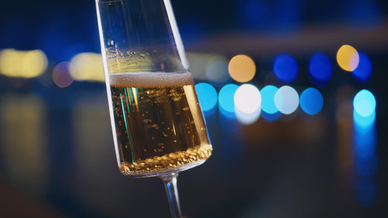 Elegant glass sparkling wine in hand unrecognizable partygoer at night closeup